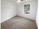 Empty bedroom with neutral carpet and a window at 4727 Garden Hills Dr, Stone Mountain, GA 30083