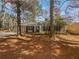 Front exterior of a single-story home surrounded by trees, featuring a driveway and walkway at 4727 Garden Hills Dr, Stone Mountain, GA 30083