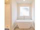 Modern bathroom with a soaking tub, separate shower, and tiled floor at 1628 Fuma Leaf Way, Mcdonough, GA 30253