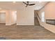 Open living area with wood-look flooring, ceiling fan, and staircase at 1628 Fuma Leaf Way, Mcdonough, GA 30253