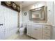 Bathroom with white cabinetry, a shower-tub combo, and floral decor at 3229 Carmichael Pl, Duluth, GA 30097