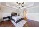 Spacious bedroom with hardwood floors, ceiling fan, and plush carpet at 3229 Carmichael Pl, Duluth, GA 30097