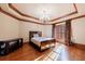 Bedroom with hardwood floors, tray ceiling with chandelier, and large windows at 3229 Carmichael Pl, Duluth, GA 30097