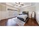 Bedroom with hardwood floors, ceiling fan, and large window with plantation shutters at 3229 Carmichael Pl, Duluth, GA 30097