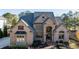 Large brick home with arched entry and professional landscaping at 3229 Carmichael Pl, Duluth, GA 30097