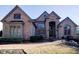 Elegant brick home with arched entryway, multiple windows, and landscaping at 3229 Carmichael Pl, Duluth, GA 30097