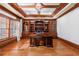 Home office with built-in wooden bookshelves, a large desk, and hardwood floors at 3229 Carmichael Pl, Duluth, GA 30097