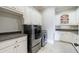Laundry room with white cabinets, dark countertops, and front-loading washer and dryer at 3229 Carmichael Pl, Duluth, GA 30097
