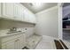 Laundry room with white cabinets, sink, and tile floor at 3229 Carmichael Pl, Duluth, GA 30097