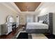 Large bedroom with a tray ceiling, plush bed, and hardwood floor at 3229 Carmichael Pl, Duluth, GA 30097