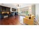 Office/den with built-in black desk and entertainment center, large TV, and two yellow chairs at 3229 Carmichael Pl, Duluth, GA 30097