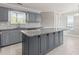 Modern kitchen with gray cabinetry, a large island with granite countertops, and stainless steel appliances at 231 Cambridge Dr, Loganville, GA 30052