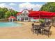 Community pool with mushroom water feature, clubhouse, tables, and red umbrellas at 631 Egrets Lndg, Covington, GA 30014