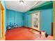 Basement area with vibrant teal walls, a glass paned door and red flooring at 680 Horsley Mill Rd, Carrollton, GA 30116