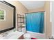 Clean bathroom with blue shower curtain, vanity sink, and black-framed mirror at 680 Horsley Mill Rd, Carrollton, GA 30116