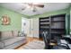 Multi-functional room featuring a sofa, bookshelves, and office setup in a green-painted room at 2307 Hunting Valley Dr, Decatur, GA 30033