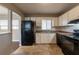 Functional kitchen with white cabinets, black appliances, and tile flooring at 316 W Downing Ct, Jonesboro, GA 30238