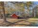 Red barn or outbuilding nestled within a wooded area at 8450 Union Grove Rd, Lithonia, GA 30058