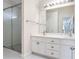 Bright bathroom with double vanity, white cabinets, large mirror, and glass shower at 1547 Welch Ct, Suwanee, GA 30024