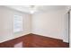 Empty bedroom with hardwood floors, white walls, window, and ceiling fan at 1547 Welch Ct, Suwanee, GA 30024