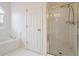 Main bathroom with soaking tub, separate shower, and white tile floors at 1547 Welch Ct, Suwanee, GA 30024