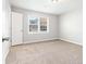 Empty bedroom with neutral walls, carpeting, and a window with blinds at 1121 Kelvington Way, Lilburn, GA 30047