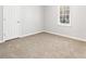 Empty bedroom with carpet, simple white walls, and natural light from a window at 1121 Kelvington Way, Lilburn, GA 30047