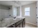 Bathroom with dark vanity, granite countertop, and a window at 5537 Union Pointe Pl, Union City, GA 30291