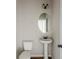Simple powder room with pedestal sink and oval mirror at 5537 Union Pointe Pl, Union City, GA 30291