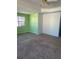 Spacious bedroom with light green and blue walls, ceiling fan, and neutral carpeting at 1276 Huntington Place Cir, Lithonia, GA 30058