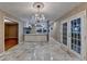 Dining room with tile floor, chandelier, French doors leading to the backyard, and a view of the kitchen at 3479 Chestnut Dr, Atlanta, GA 30340