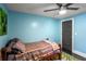 Light blue bedroom with a bed, ceiling fan, and dark gray door at 770 Rochelle Sw Dr, Atlanta, GA 30310