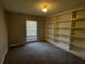 Cozy bedroom/den/office space with neutral walls, built-in bookshelves, and plush carpet at 125 Woodhawk Ln, Stockbridge, GA 30281