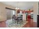 Dining area with hardwood floors, a table with seating for four, and view of the kitchen at 3915 Cutler Donahoe Way, Cumming, GA 30040