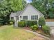 White house with gray shutters, stone accents, and a landscaped lawn at 7115 Shady Oak Ln, Cumming, GA 30040