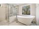 Luxurious bathroom with a soaking tub, walk-in shower, and marble tile at 115 West Ct, Johns Creek, GA 30097