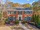 Brick two-story house with green shutters and a landscaped yard at 115 West Ct, Johns Creek, GA 30097