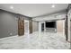 Open basement space with entertainment area and barn doors at 3640 Sentry View Trce, Suwanee, GA 30024