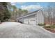 Two-car garage with long driveway and wooded backdrop at 38 Timberlost Trl, Suwanee, GA 30024