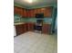 Kitchen features wood cabinets, granite counters, and tile floors at 1306 Warsaw Rd, Roswell, GA 30076