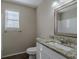 Bathroom boasts granite countertop, white vanity, and window with blinds at 1275 Mill Lake Cir, Stone Mountain, GA 30088