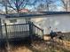 Backyard with a dark wooden deck, grill, and white brick exterior at 1543 California Ave, Conley, GA 30288