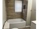 Bathroom with a bathtub/shower combo, wood-look flooring, and modern fixtures at 1543 California Ave, Conley, GA 30288