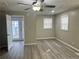Spacious bedroom with wood-look flooring, ceiling fan, and access to the backyard at 1543 California Ave, Conley, GA 30288