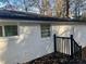 White brick exterior with black trim and a black railing leading to a wooden deck at 1543 California Ave, Conley, GA 30288