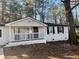 White home with black shutters, covered front porch, and landscaped yard at 1543 California Ave, Conley, GA 30288