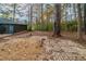 Wooded backyard with a brick patio and screened-in porch at 5136 Huxley Rd, Stone Mountain, GA 30088