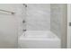 White bathtub and shower combination in renovated bathroom at 5136 Huxley Rd, Stone Mountain, GA 30088