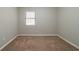 Unfurnished bedroom with window, neutral walls, and carpeting at 5136 Huxley Rd, Stone Mountain, GA 30088