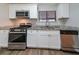 Modern kitchen boasts stainless steel appliances, white shaker cabinets, granite countertops, and ample counter space at 5136 Huxley Rd, Stone Mountain, GA 30088